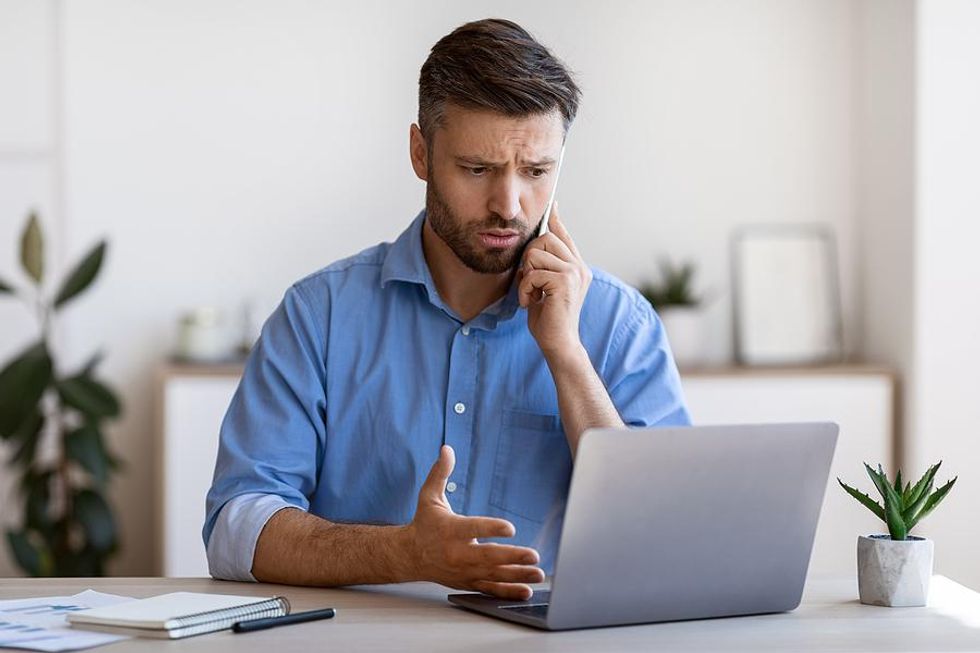 Man on laptop dealing with workplace conflict at work