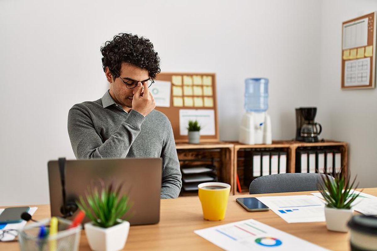 Man on laptop is miserable at work