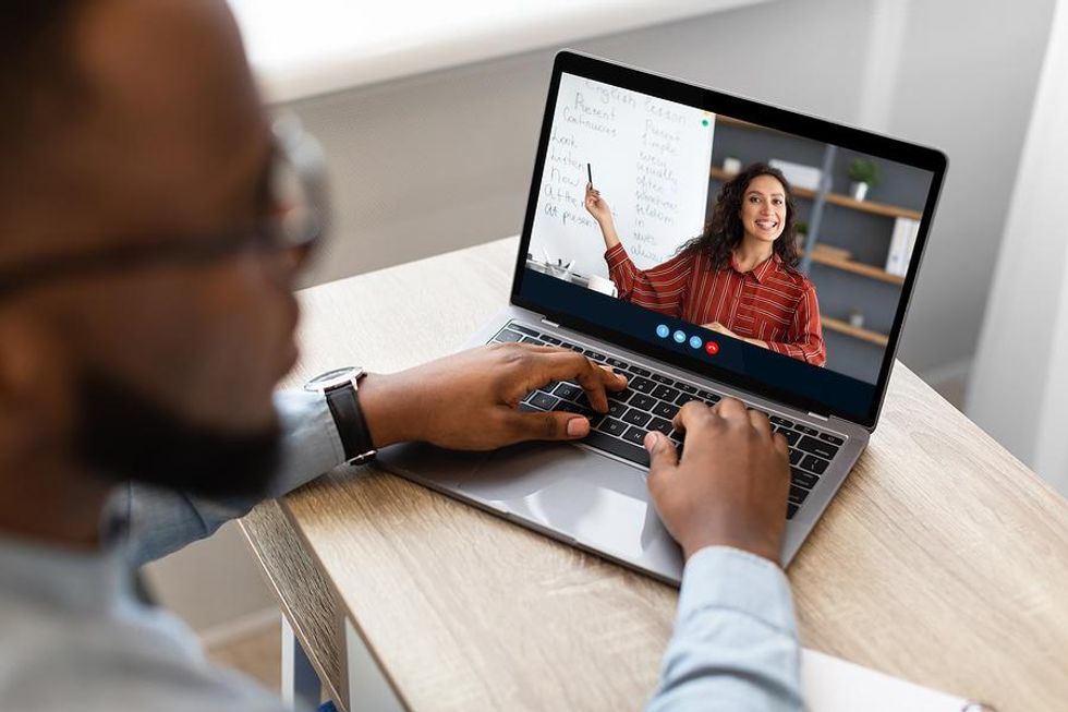 Man on laptop listens to a teacher