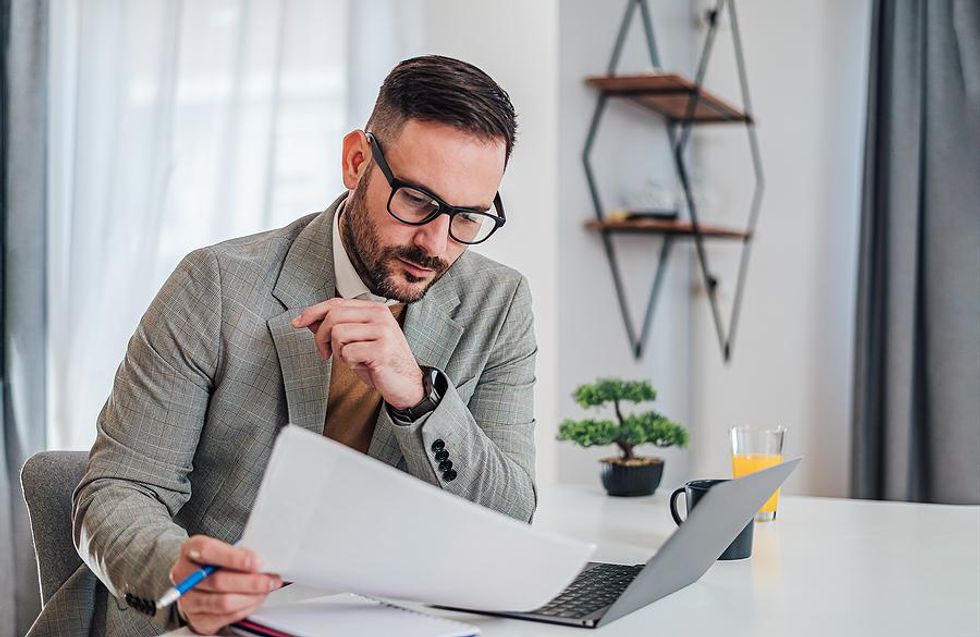 Man on laptop looks at a spreadsheet