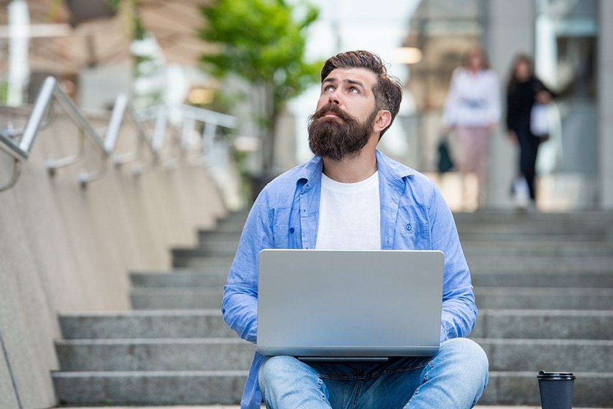 Man on laptop looks for a job while still employed