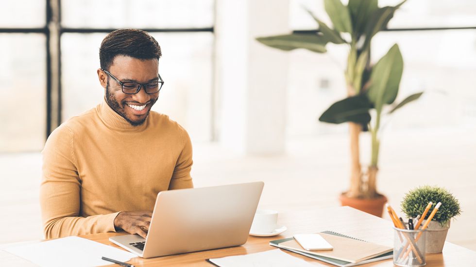 Man on laptop reads up on his industry while unemployed