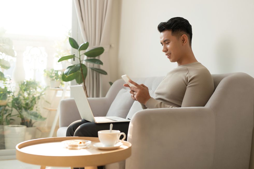 Man on laptop reviews his resume and LinkedIn profile after being laid off