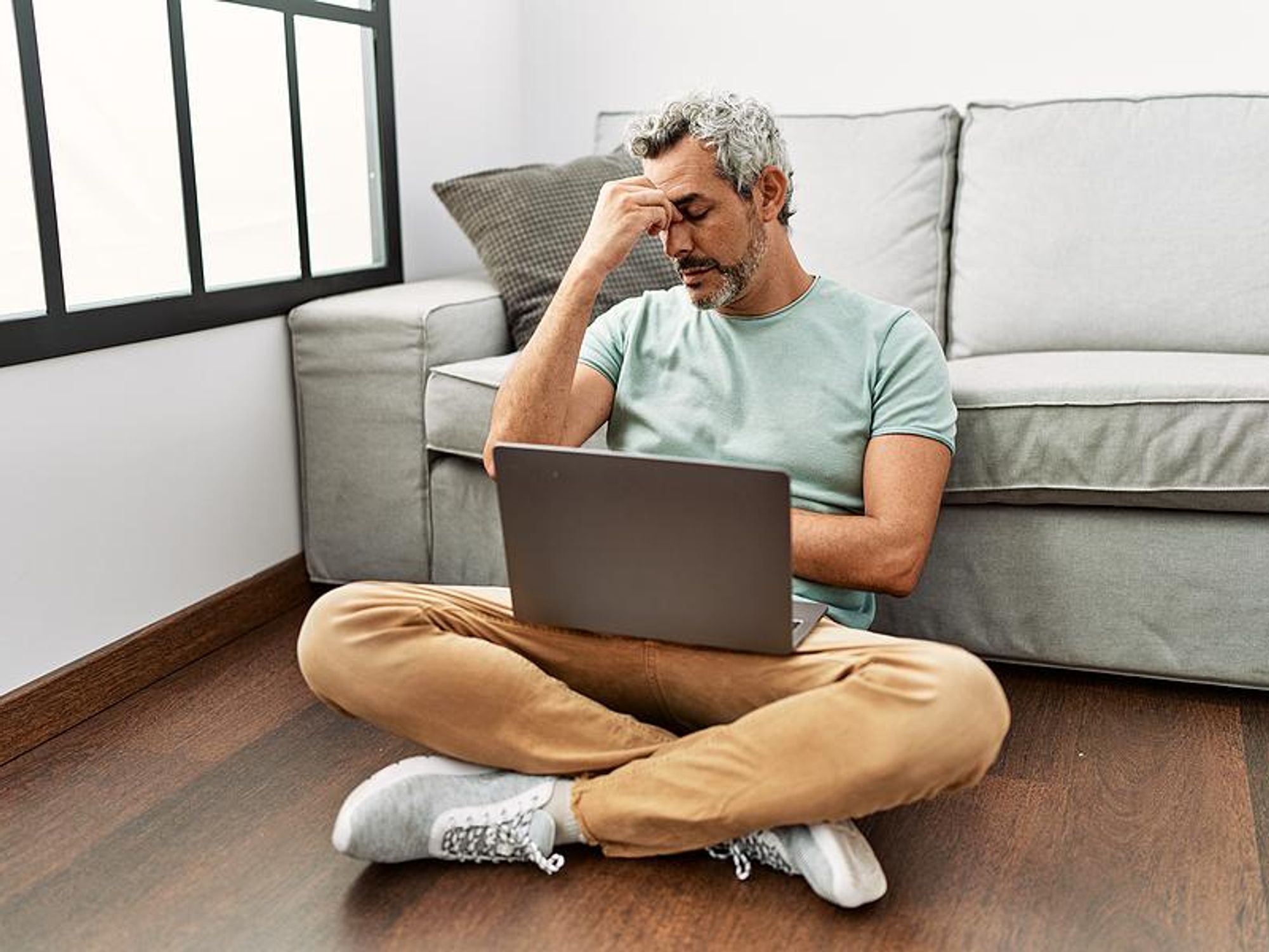 Man on laptop stressed about finding a new job