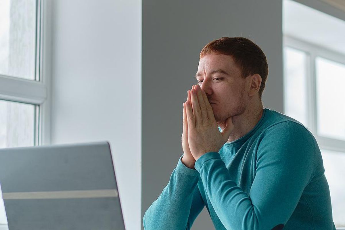 Man on laptop struggles to write his resume after getting fired
