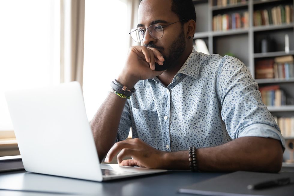 Man on laptop thinking about how to format his resume