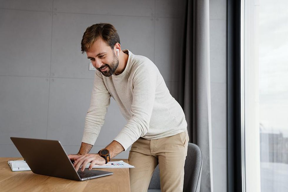 Man on laptop updates his LinkedIn profile with achievements