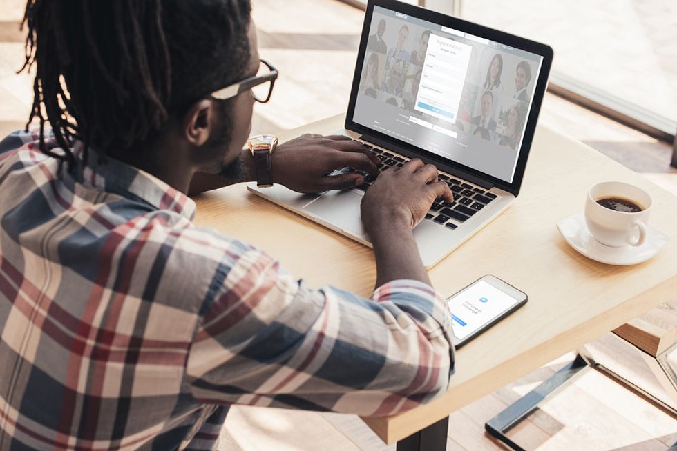 Man on laptop updates his LinkedIn profile