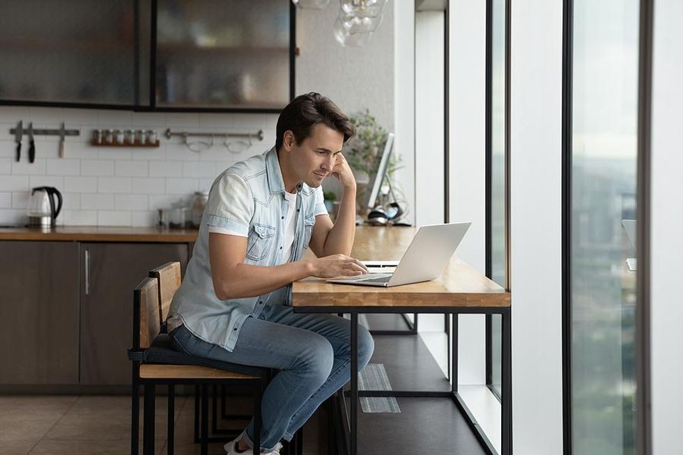 Man on laptop updates his LinkedIn profile