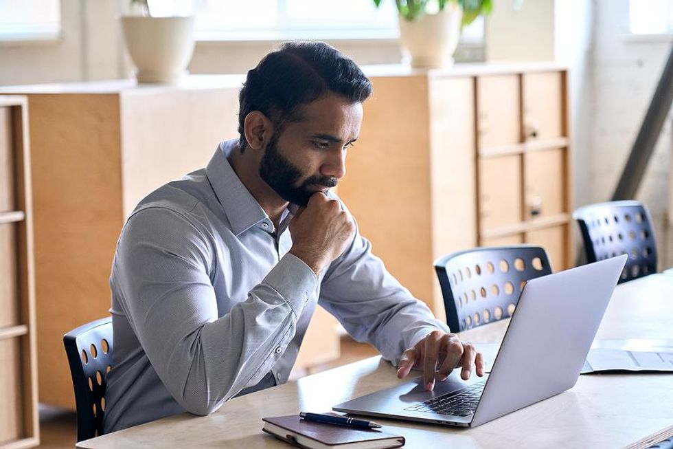 Man on laptop updates his LinkedIn profile