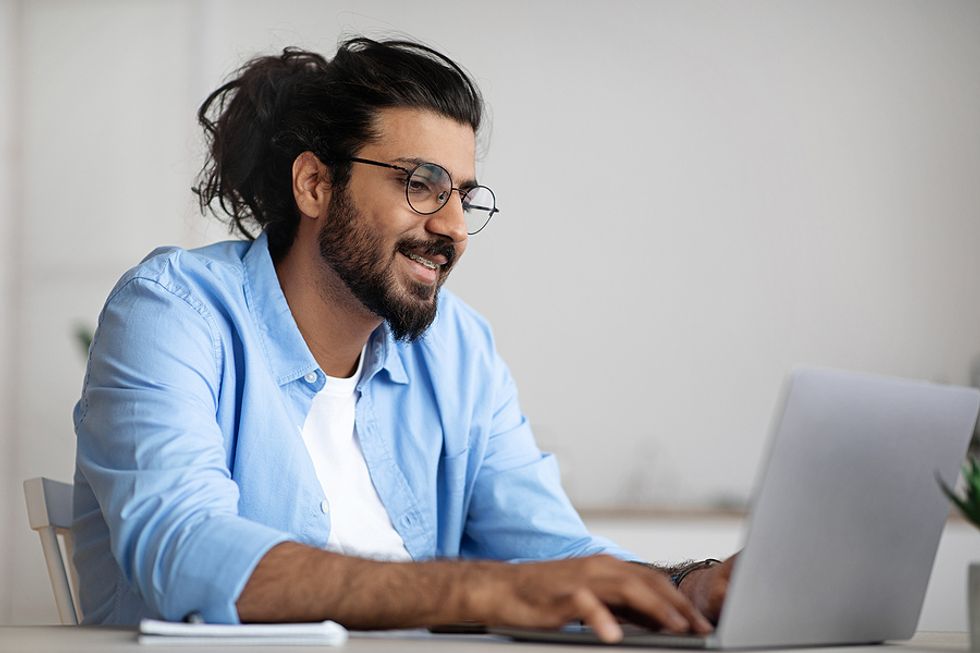 Man on laptop uses powerful words on his resume