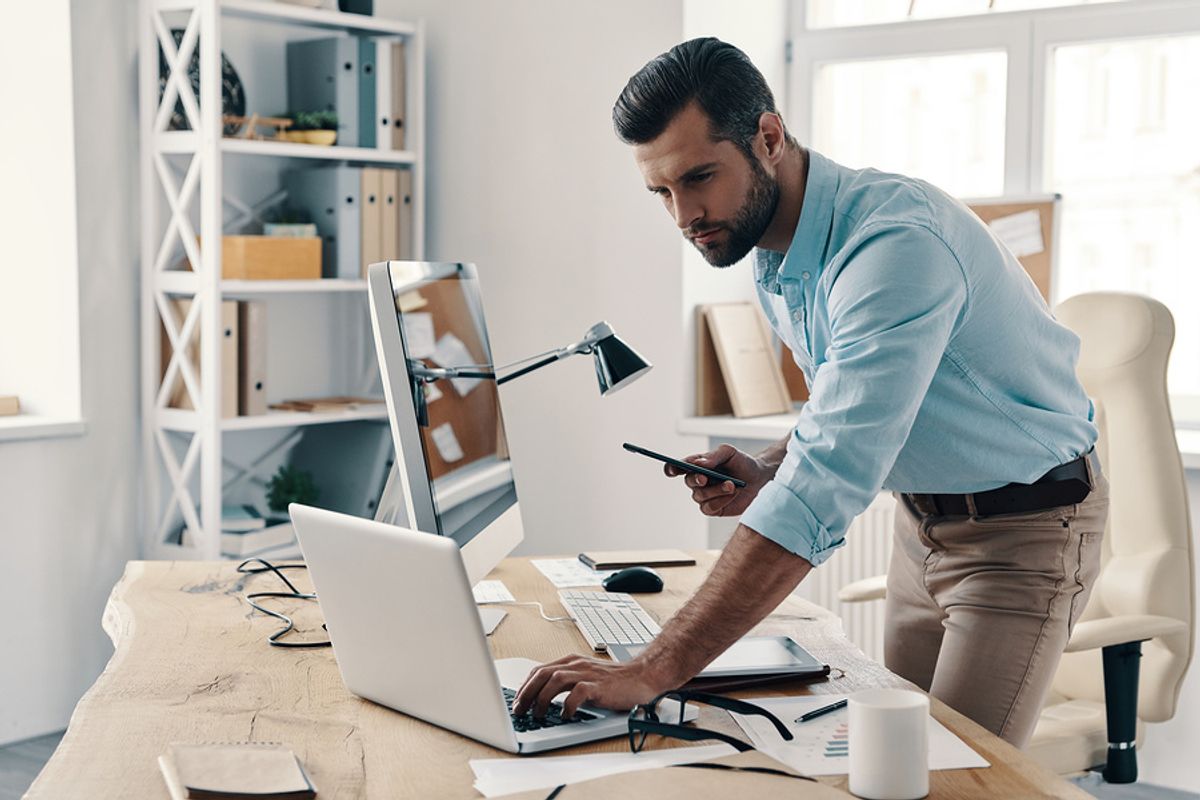 Man on laptop works on his side hustle while working full time