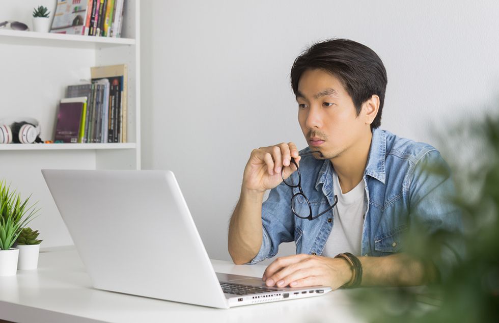 Man on laptop works remotely from home