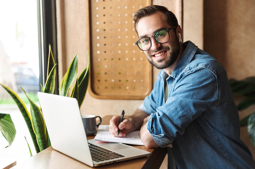 Man on laptop writing quantifiable achievements on resume