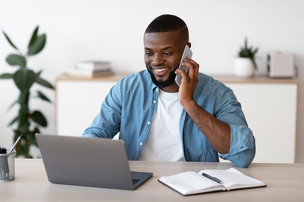 Man on phone and laptop leaves a voicemail for a job