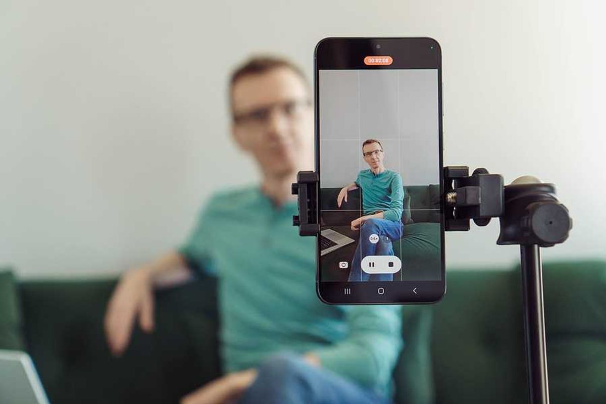 Man recording a video on his phone to post on LinkedIn to boost his career visibility