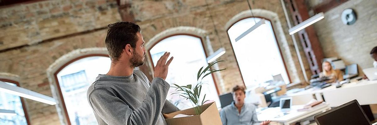 Man says goodbye to his coworkers as he leaves his job