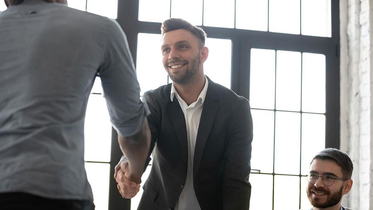Man shakes hands after successfully getting his foot in the door at a company
