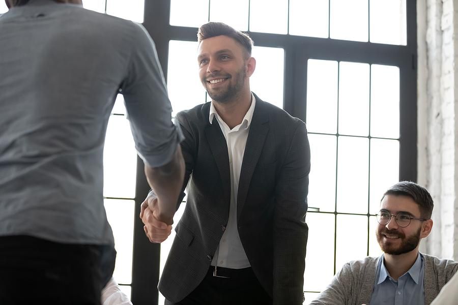 Man shakes hands after successfully getting his foot in the door at a company