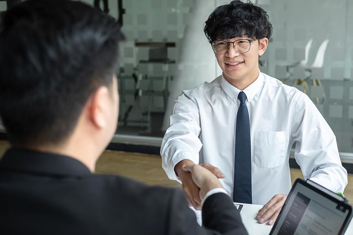 Man shakes hands before an interview