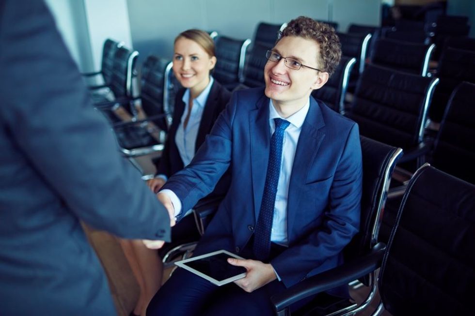 Man shakes hands with a colleague at work