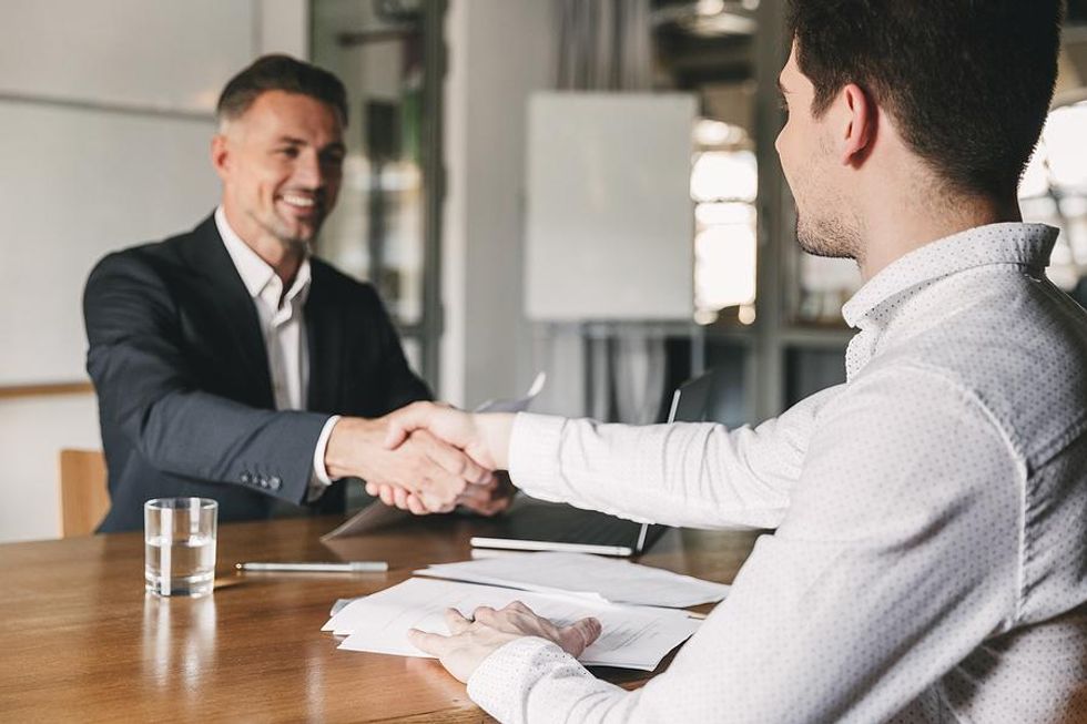 Man shakes hands with an executive after his job interview
