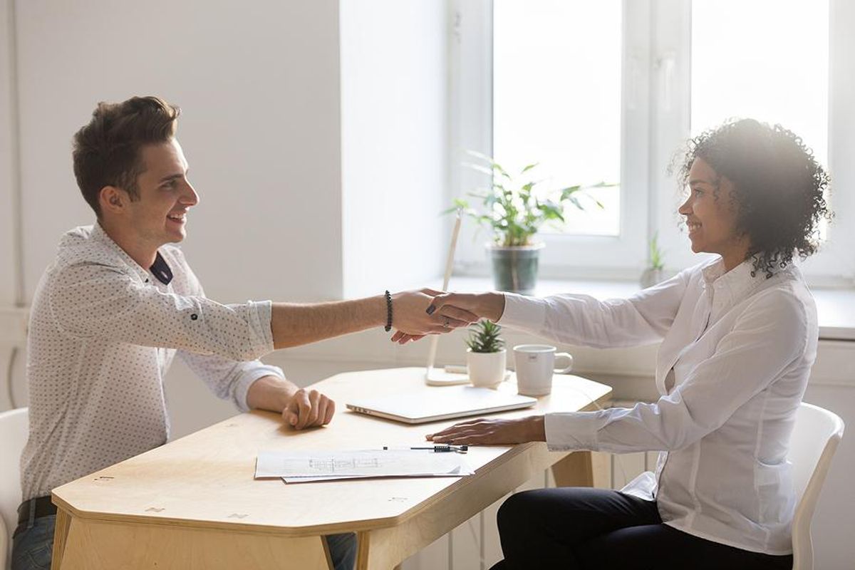 Man shakes hands with hiring manager after a job interview