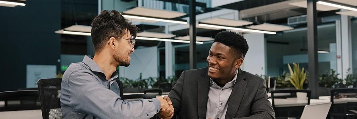 Man shakes hands with his boss after he gives him a raise