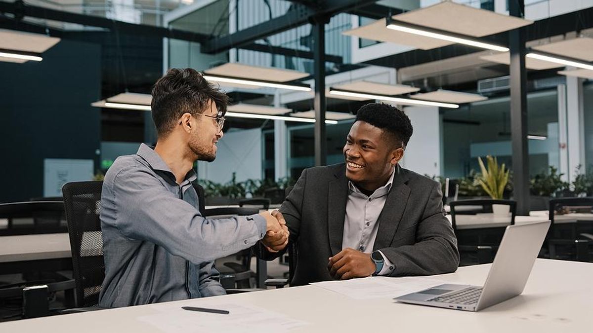 Man shakes hands with his boss after he gives him a raise
