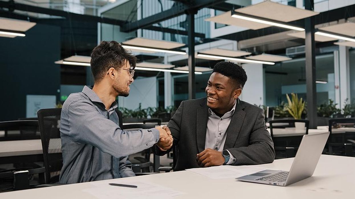 Man shakes hands with his boss after he gives him a raise