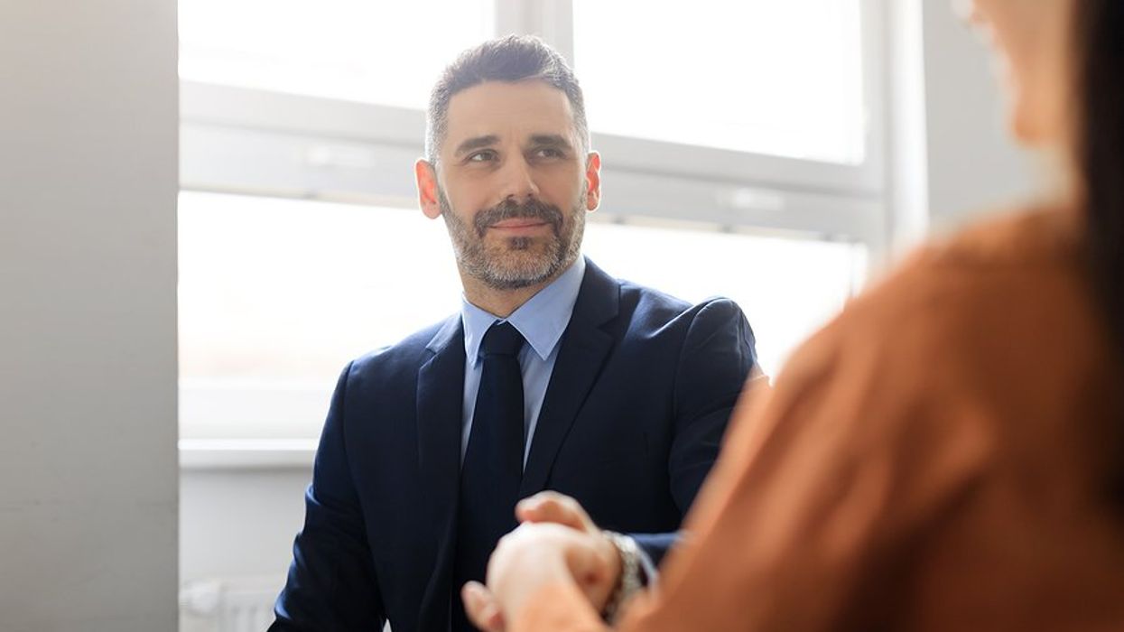Man shakes hands with the hiring manager after answering, "Why shouldn't we hire you?" in his job interview