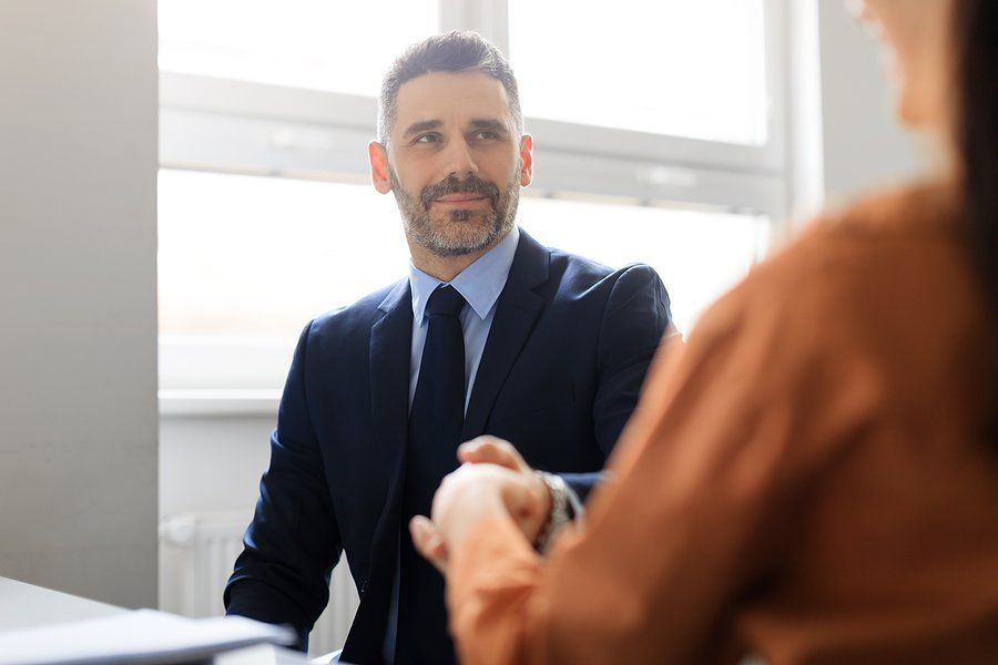 Man shakes hands with the hiring manager after answering, "Why shouldn't we hire you?" in his job interview