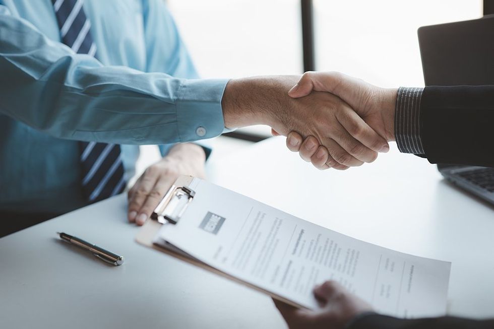 El hombre le da la mano al entrevistador/gerente de contratación después de la entrevista de trabajo