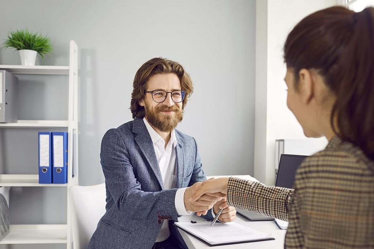 Man shakes hands with woman before a job interview