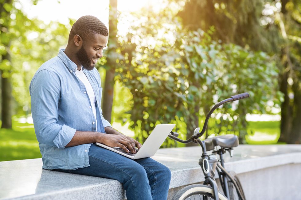 Man sits outside and works on recruiting job candidates during the summer