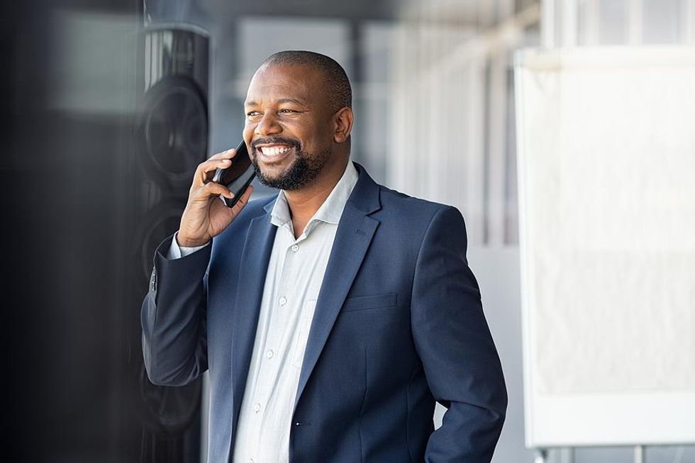 Man smiles after asking a question during a phone interview