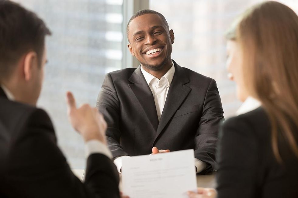 Man smiles during his interview with executives
