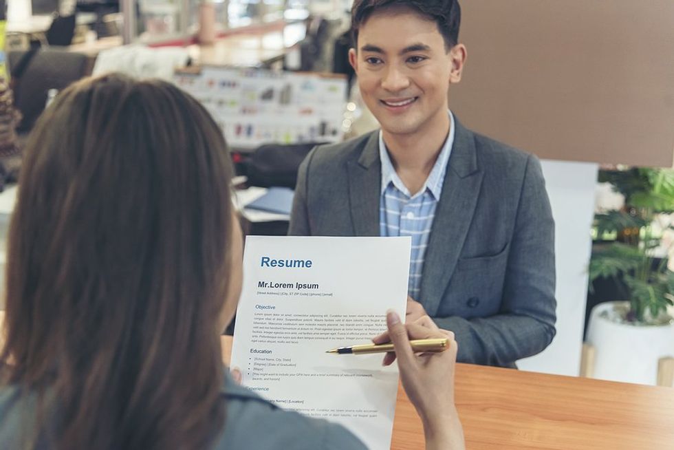 Man smiles while the interviewer / hiring manager reads his resume during a job interview