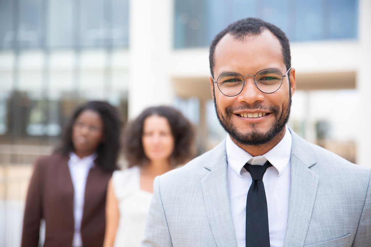 Man smiling after tailoring his resume for a leadership role and landing a leadership position