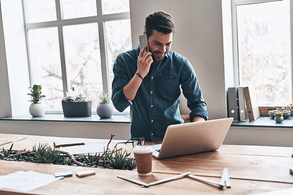 Man talking on phone and working on laptop starts a conversation with a new LinkedIn connection