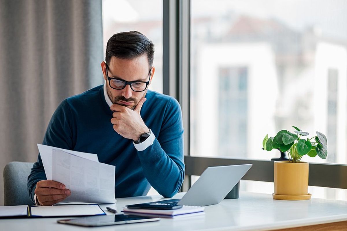 Man thinks while holding his executive resume