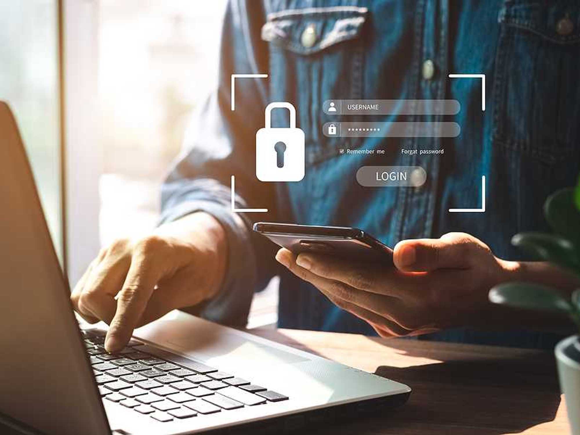 Man tries to log in to his laptop and phone, cybersecurity concept