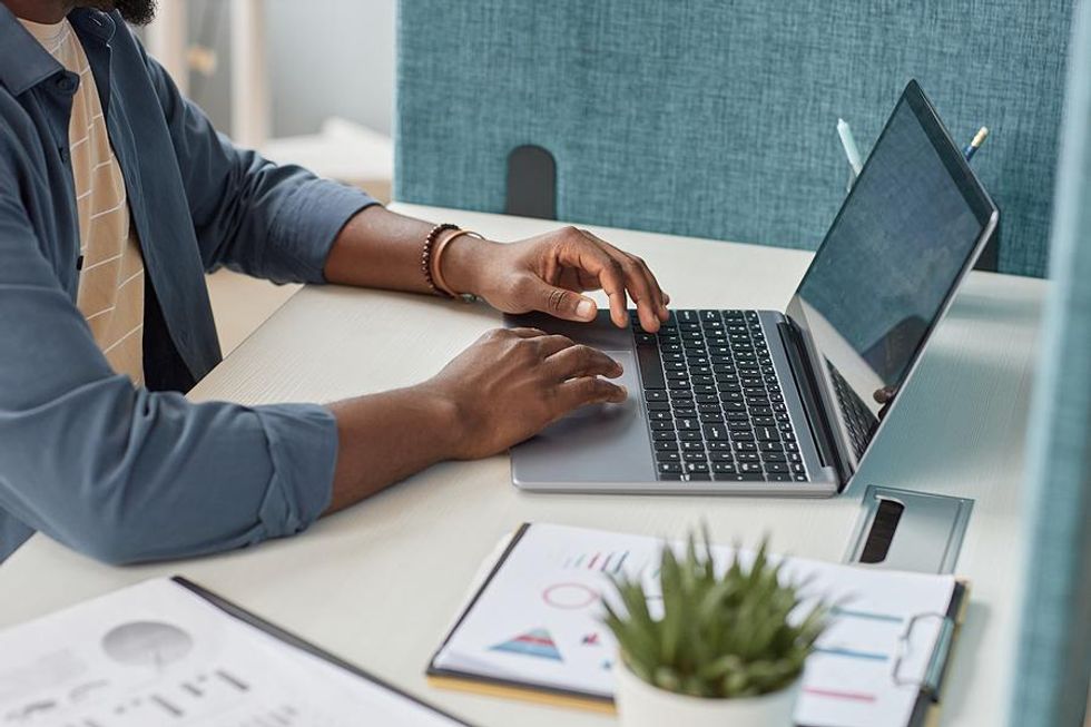 Man types something on his laptop at work