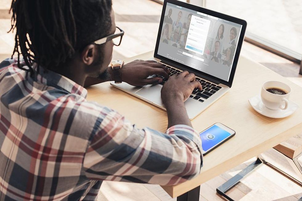 Man updates his LinkedIn profile on his laptop
