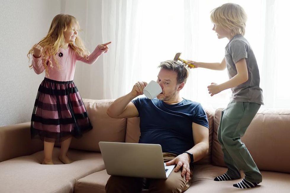 Man works from home while his children play on the couch