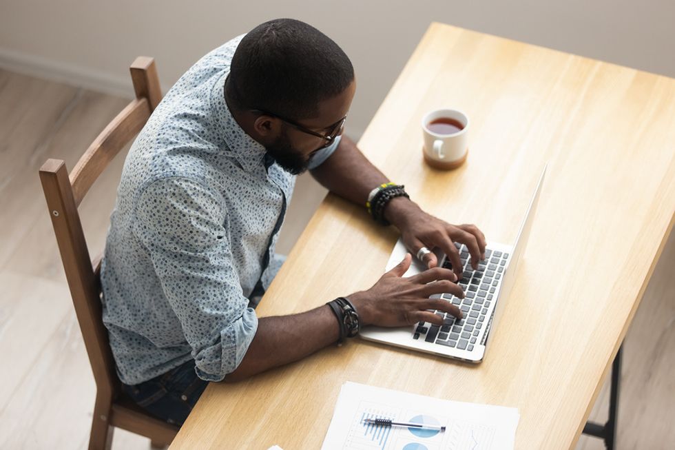 Man writes a thank-you note to an employer on his laptop