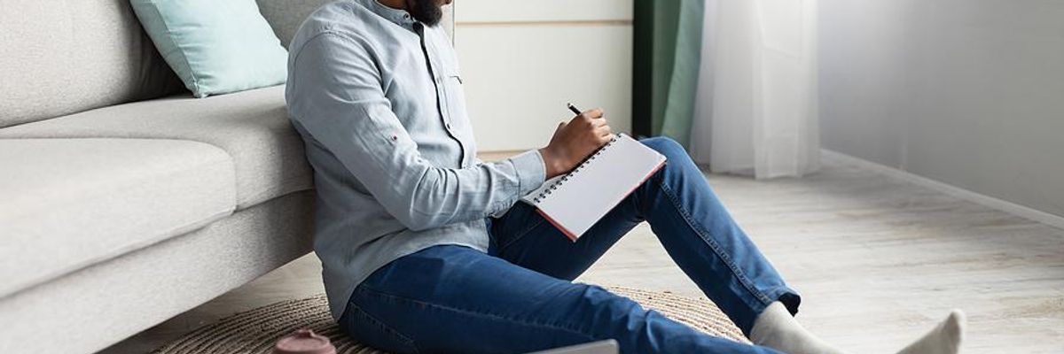 Man writes down his answers to interview questions the day before his job interview
