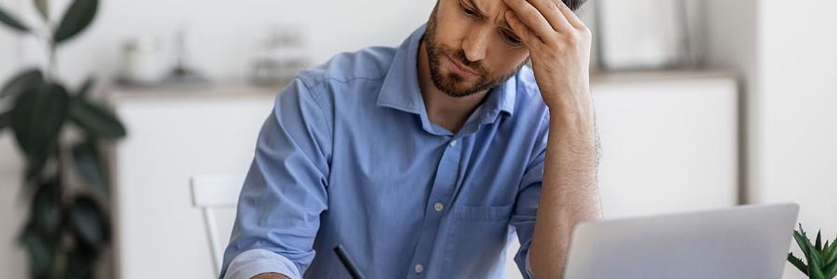 Man writes something down as he looks for a job during a recession