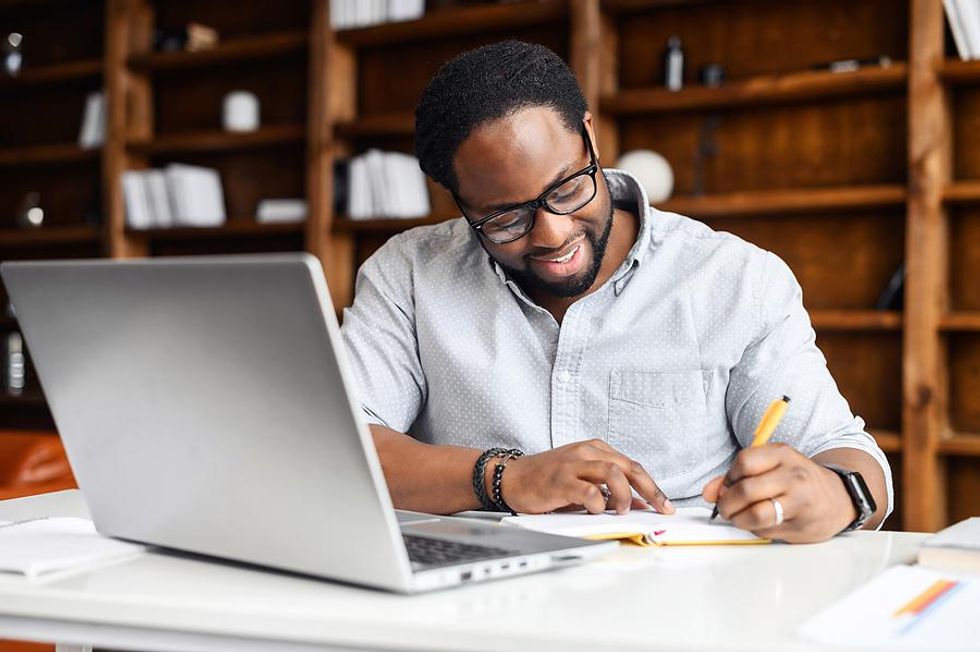 Man writing in his agenda plans out his day at work