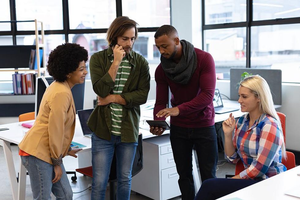 Manager helps his employees with a technology issue